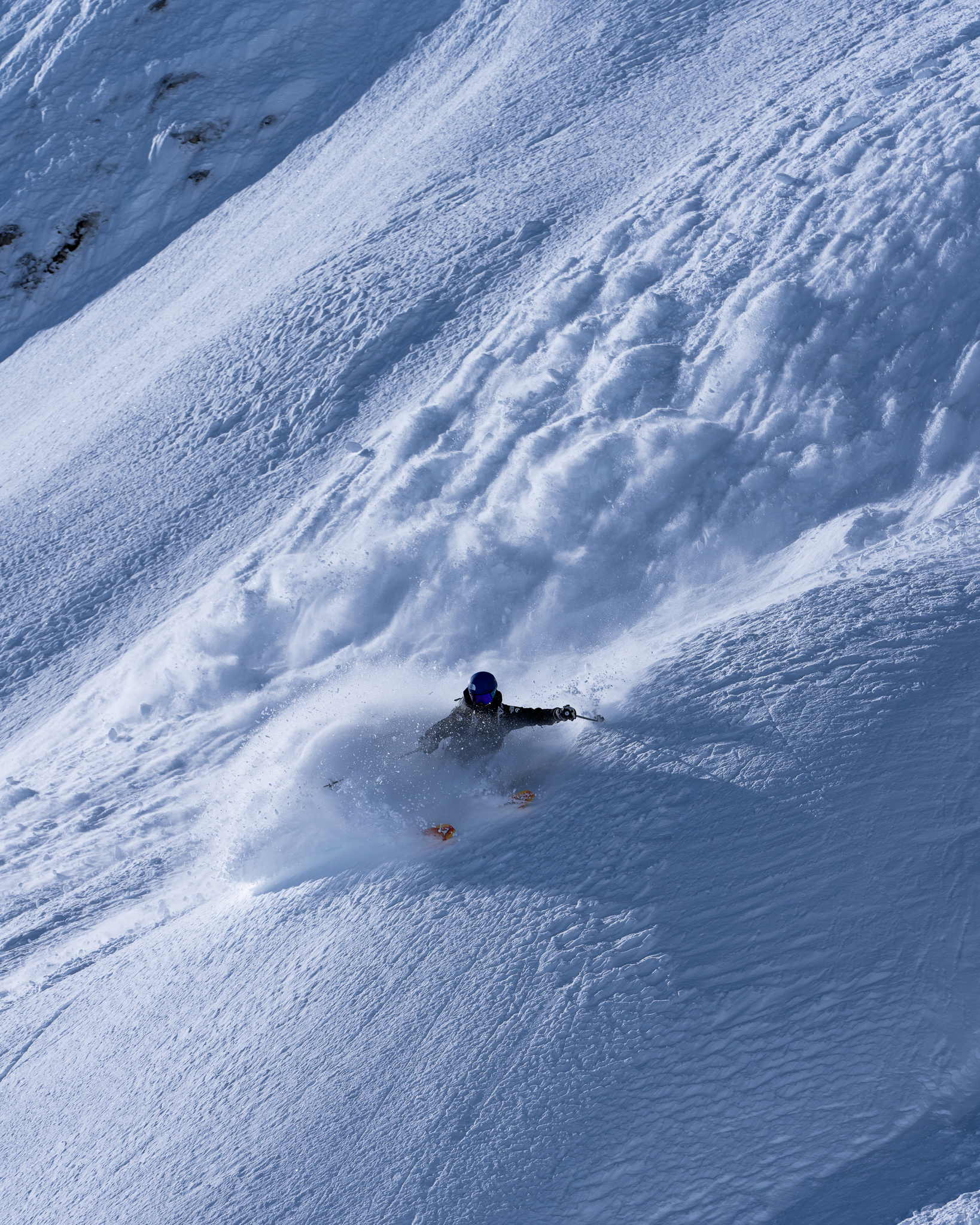 Janelle Yip makes a sharp turn skiing in deep snow on the side of a mountain