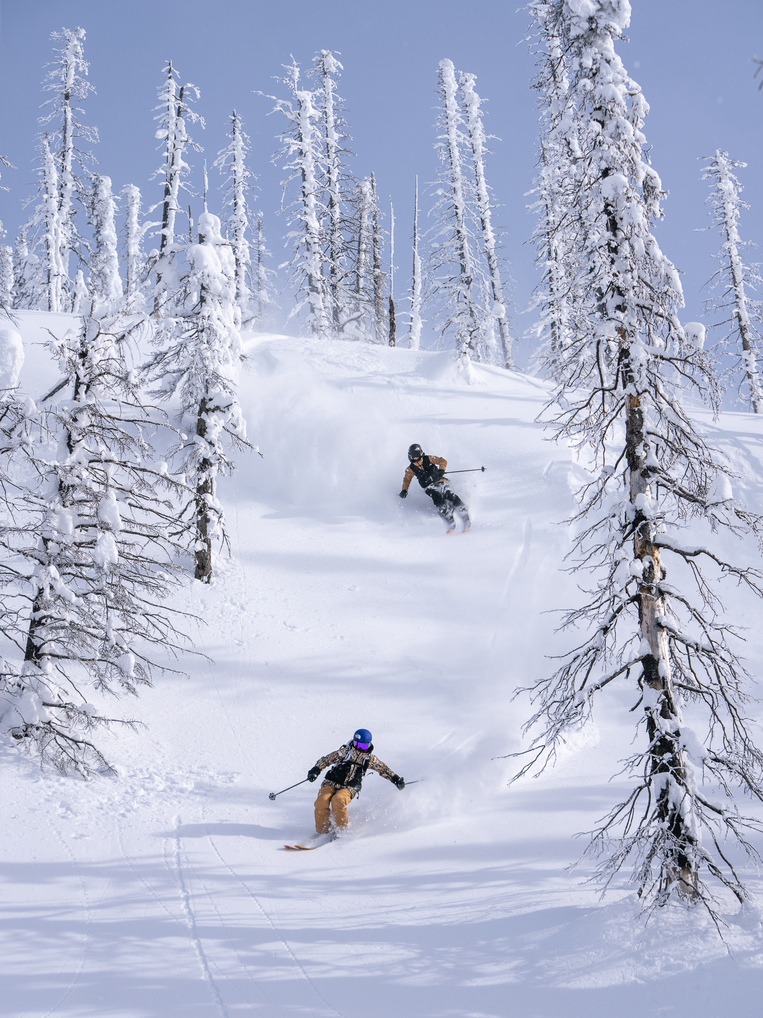 Tonje Kvivik and Janelle Yip ski down a slope in deep snow
